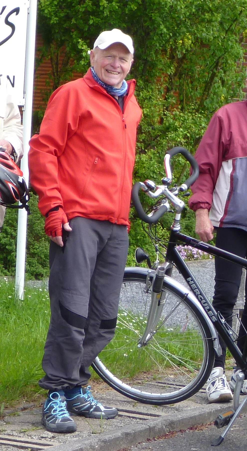 Ein Mann steht neben seinem Fahrrad und lächelt, im Hintergrund grüne Wiese und Bäume. | © DAV Dortmund