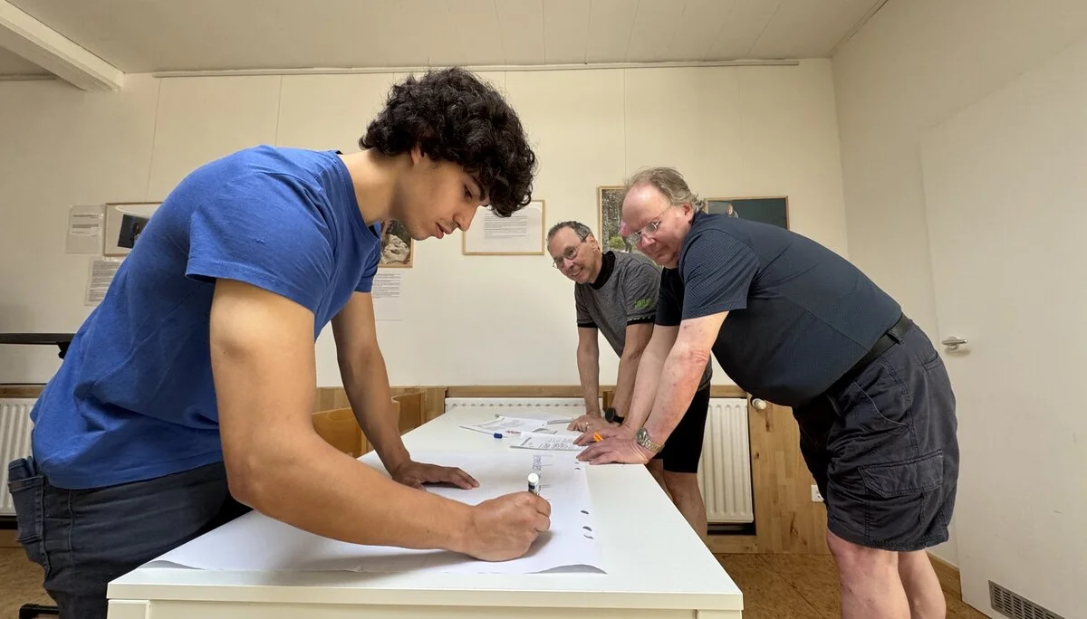 Drei Männer diskutieren und schreiben gemeinsam an einem Planungspapier. | © DAV Dortmund