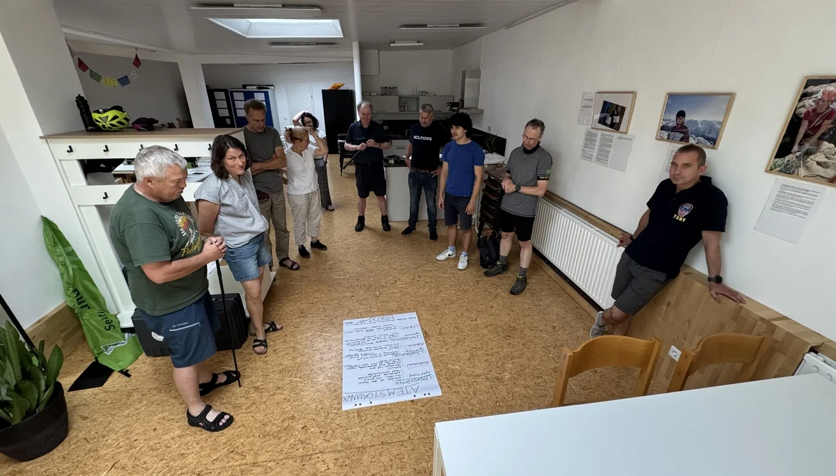 Teilnehmende stehen im Kreis und besprechen gemeinsam ein großes Plakat mit Notizen. | © DAV Dortmund