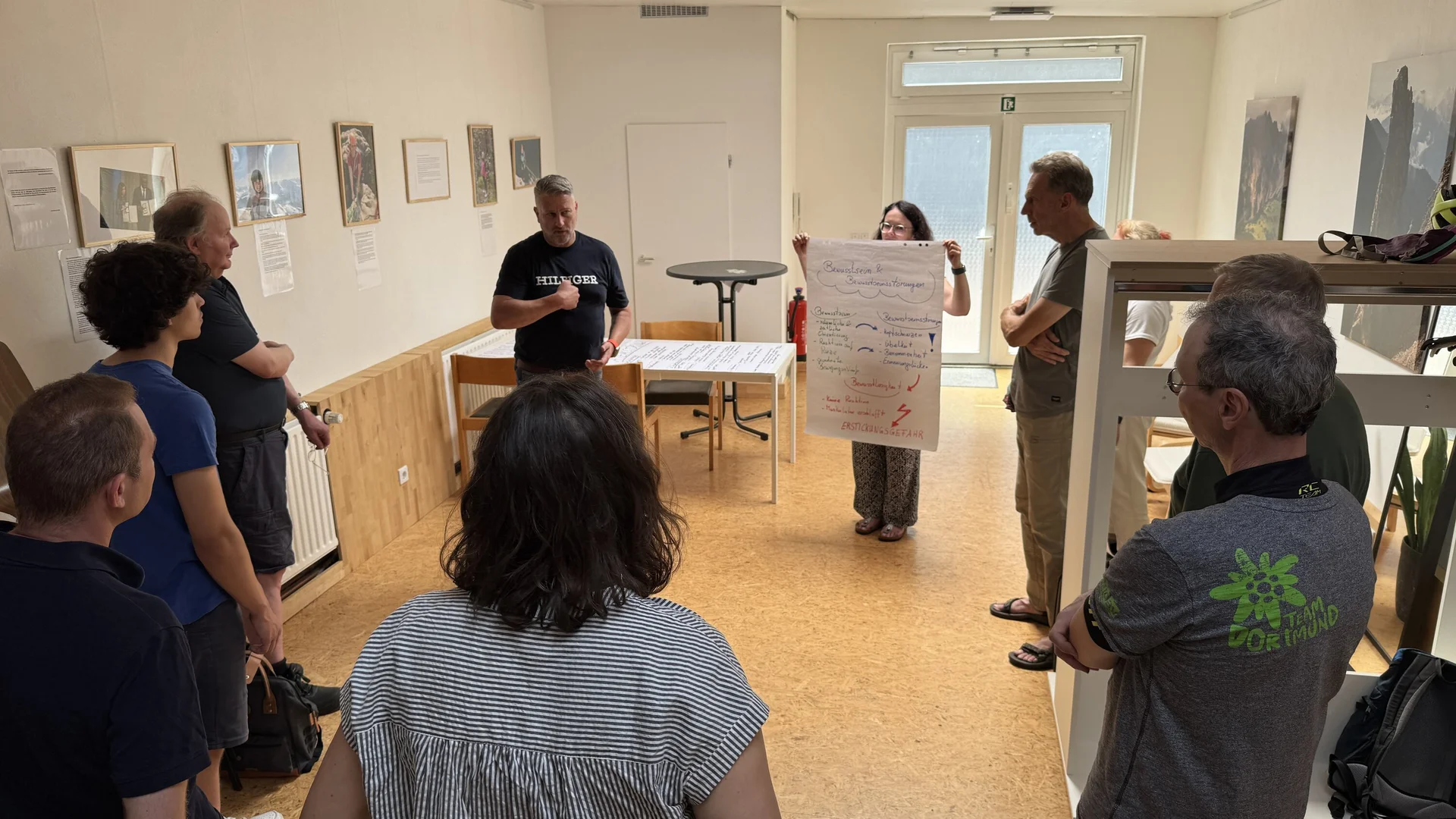  Eine Gruppe steht in einem Raum und diskutiert gemeinsam vor einem Flipchart mit Notizen. | © DAV Dortmund