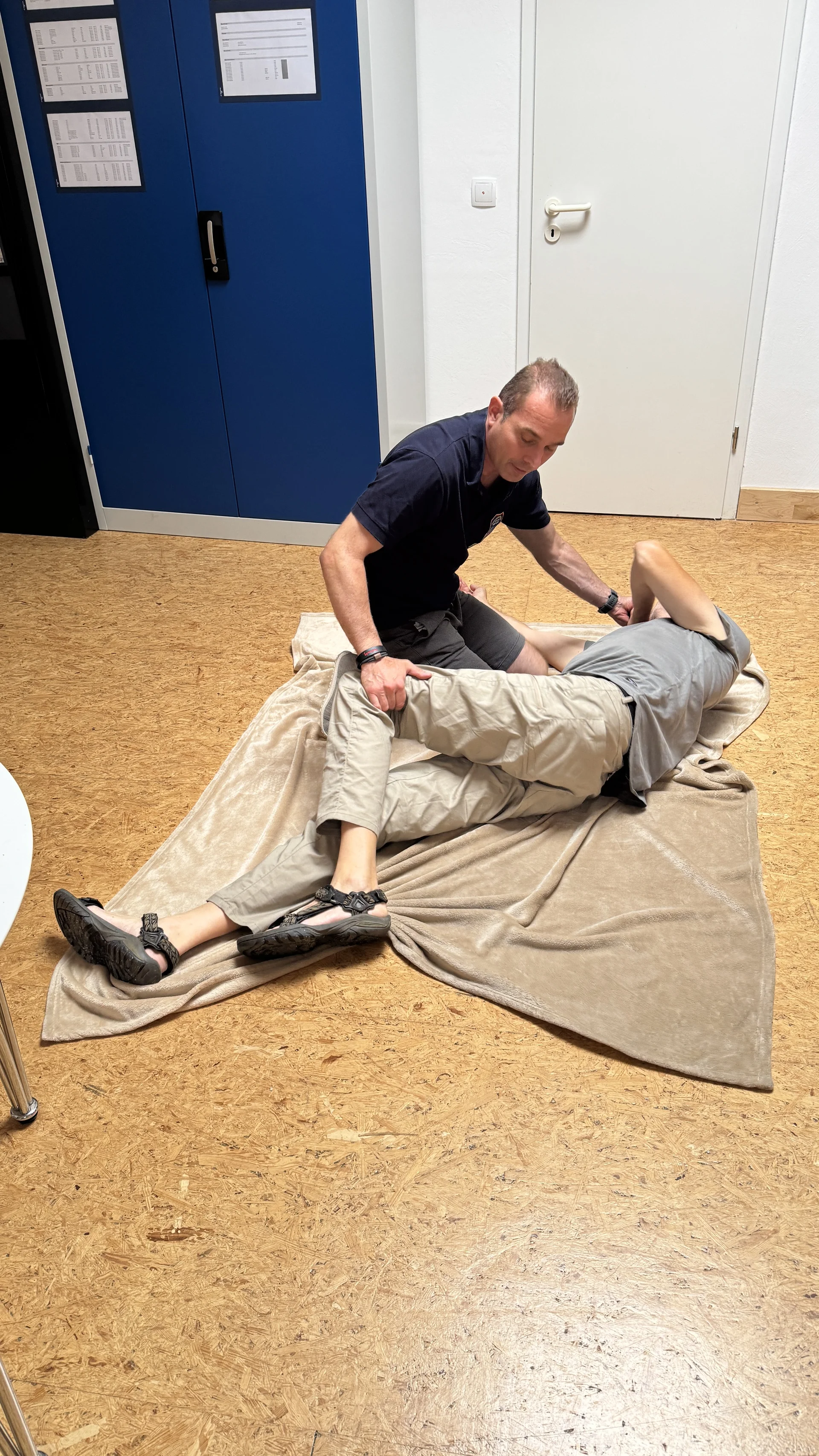 Person übt stabile Seitenlage mit einem Übungspartner auf einer Decke. | © DAV Dortmund