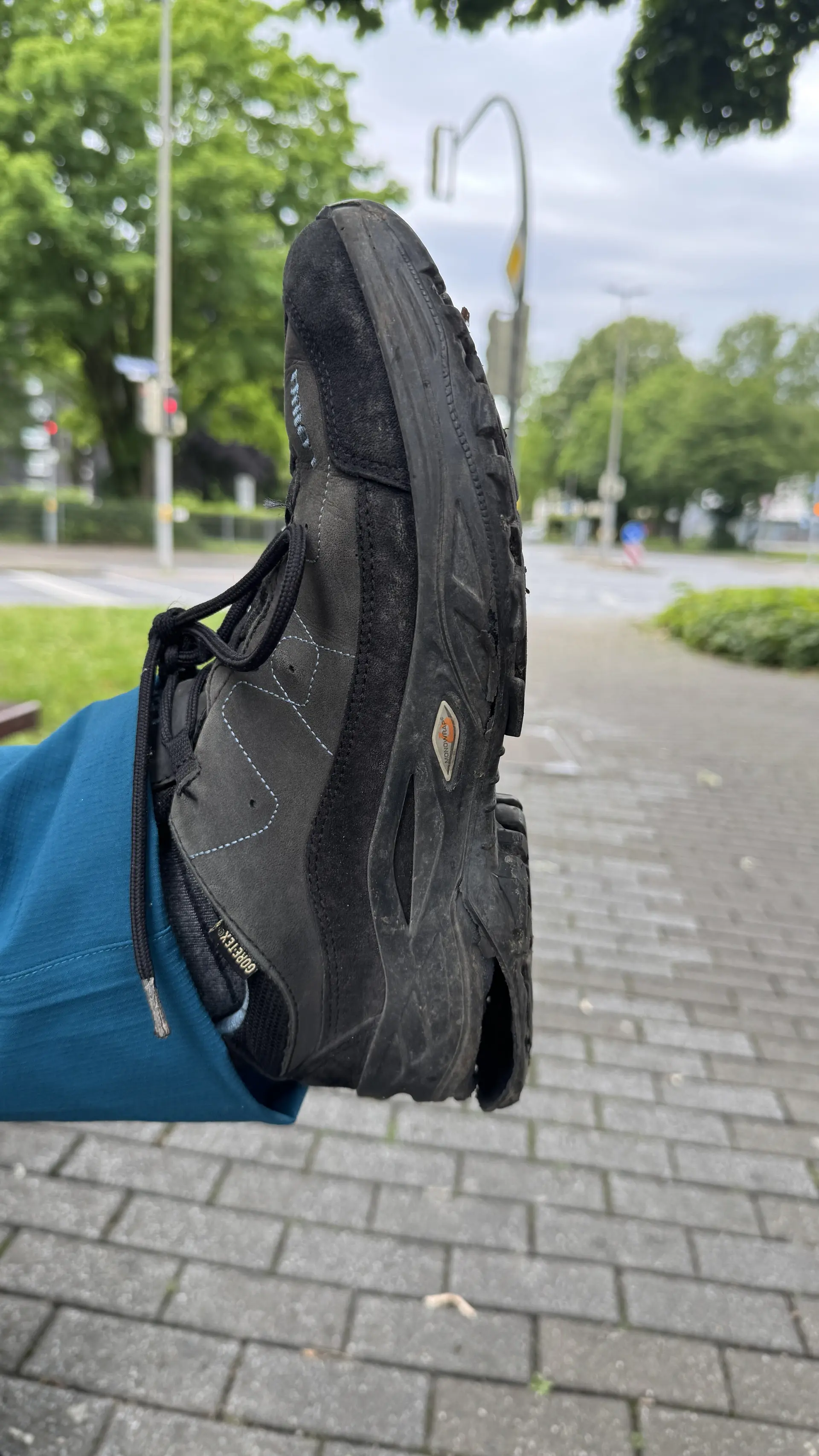 Ein schwarzer Wanderschuh mit beschädigter Sohle wird in die Kamera gehalten. | © DAV Dortmund