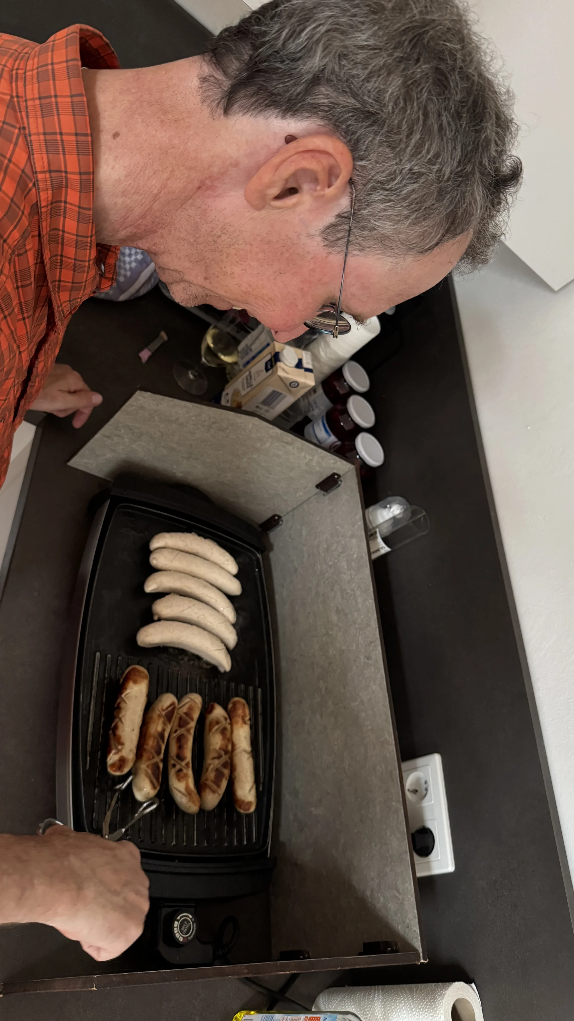 Ein Mann brät mehrere Würste in einer elektrischen Pfanne. | © DAV Dortmund