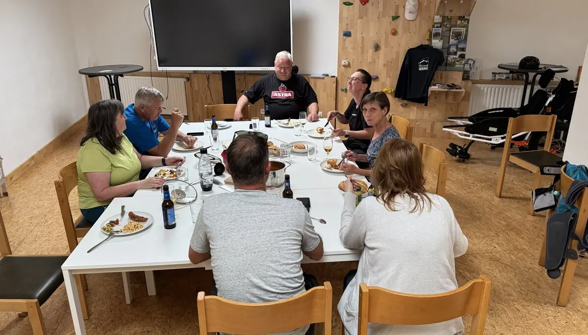 Mitglieder des DAV sitzen um einen Tisch und essen gemeinsam im Vereinsraum. | © DAV Dortmund