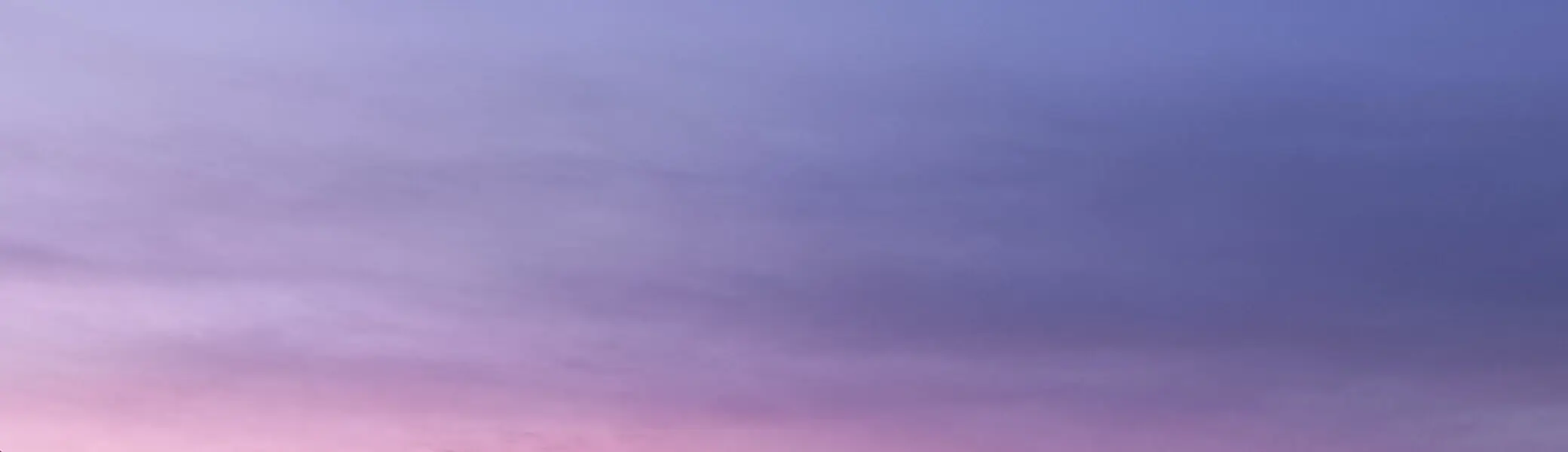 Ein Bergpanorama bei Sonnenuntergang mit violettem Himmel und markanter Säule im Vordergrund. | © DAV Dortmund