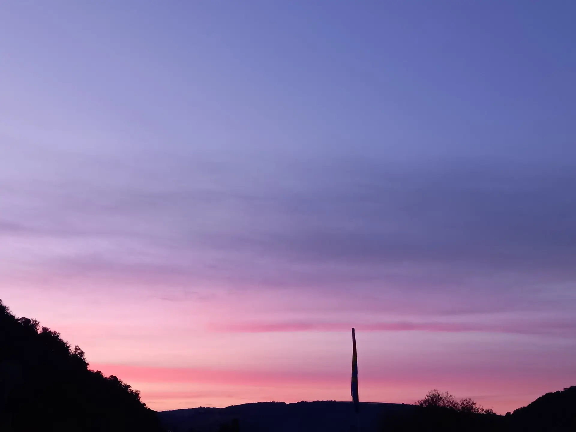 Ein Bergpanorama bei Sonnenuntergang mit violettem Himmel und markanter Säule im Vordergrund. | © DAV Dortmund