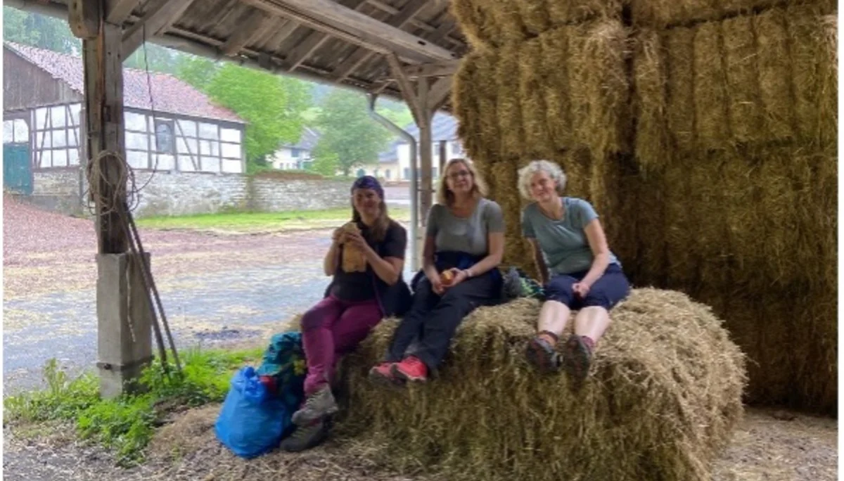 Drei Frauen sitzen entspannt auf Heuballen unter einem Schuppen | © DAV Dortmund