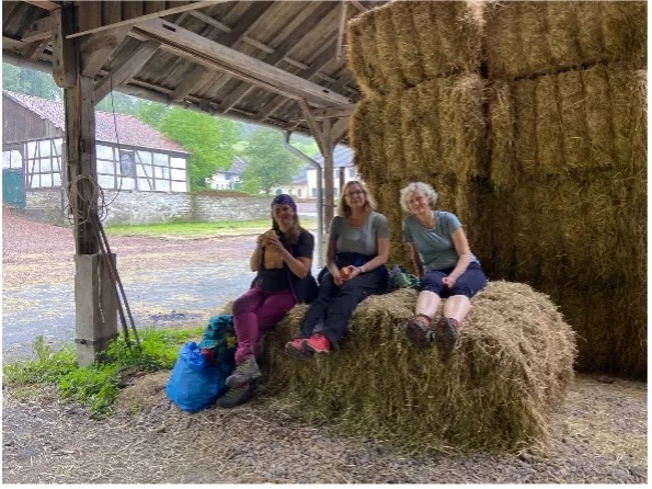 Drei Frauen sitzen entspannt auf Heuballen unter einem Schuppen | © DAV Dortmund