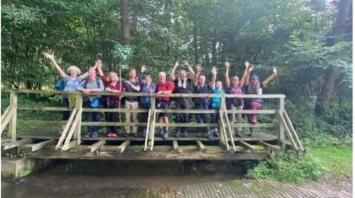 Wandergruppe jubelt auf einer kleinen Brücke im Wald. | © DAV Dortmund