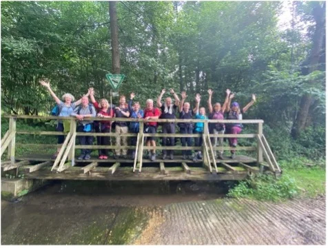 Wandergruppe jubelt auf einer kleinen Brücke im Wald. | © DAV Dortmund
