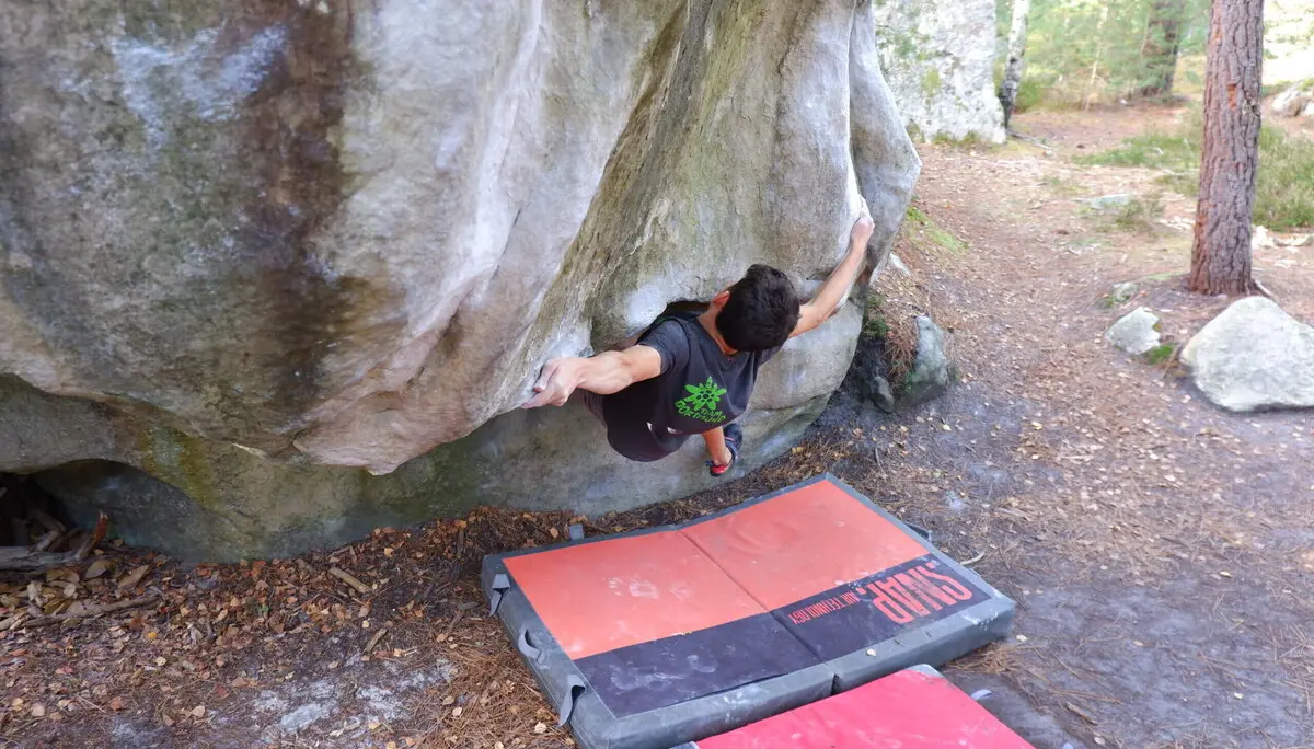 Kletterer beginnt Boulderroute mit Armgriff tief in Felshöhle | © DAV Dortmund
