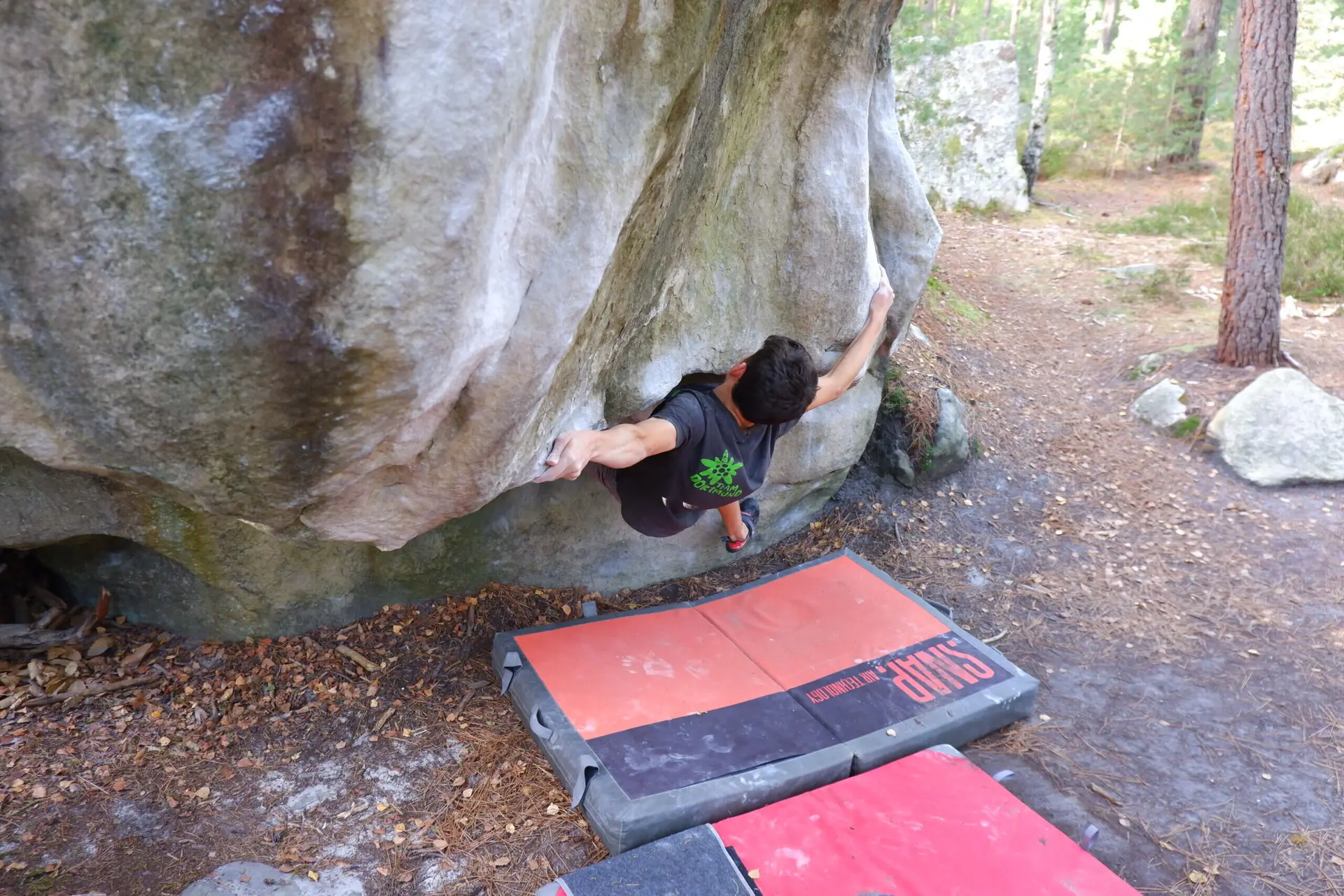 Kletterer beginnt Boulderroute mit Armgriff tief in Felshöhle | © DAV Dortmund