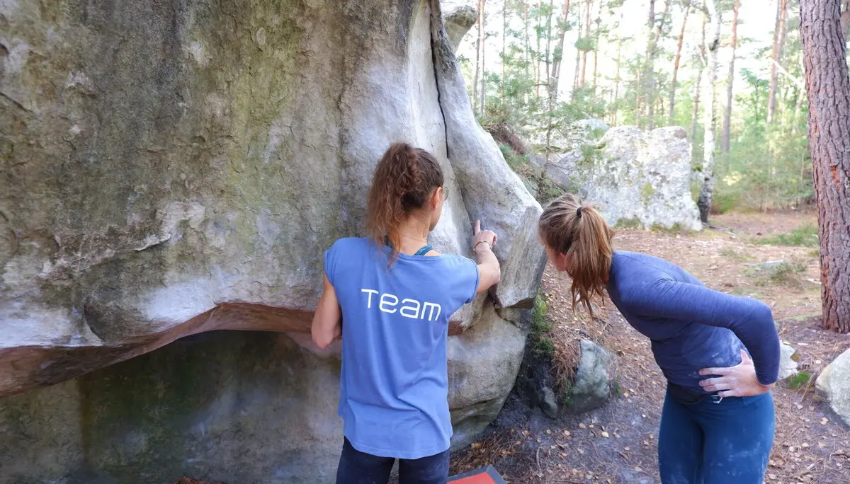 Zwei Frauen analysieren gemeinsam eine Boulderroute am Fels | © DAV Dortmund