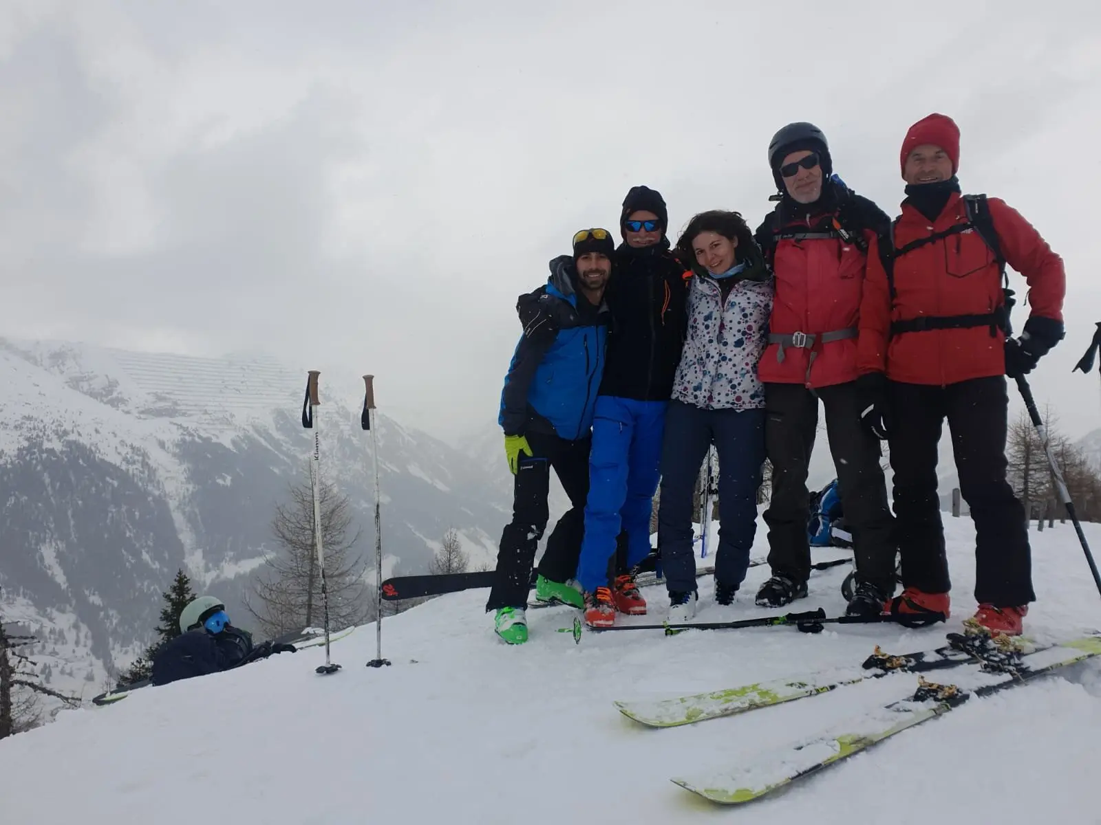 Fünf Skitourengeher*innen stehen eng beieinander auf einem winterlichen Hang, Skier liegen im Schnee. | © DAV Dortmund