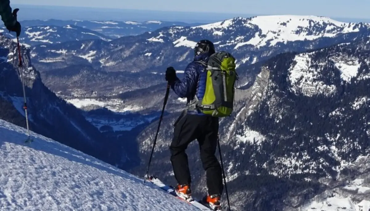 Eine Person steht mit Tourenski am Hang und blickt über ein verschneites Gebirgstal. | © DAV Dortmund