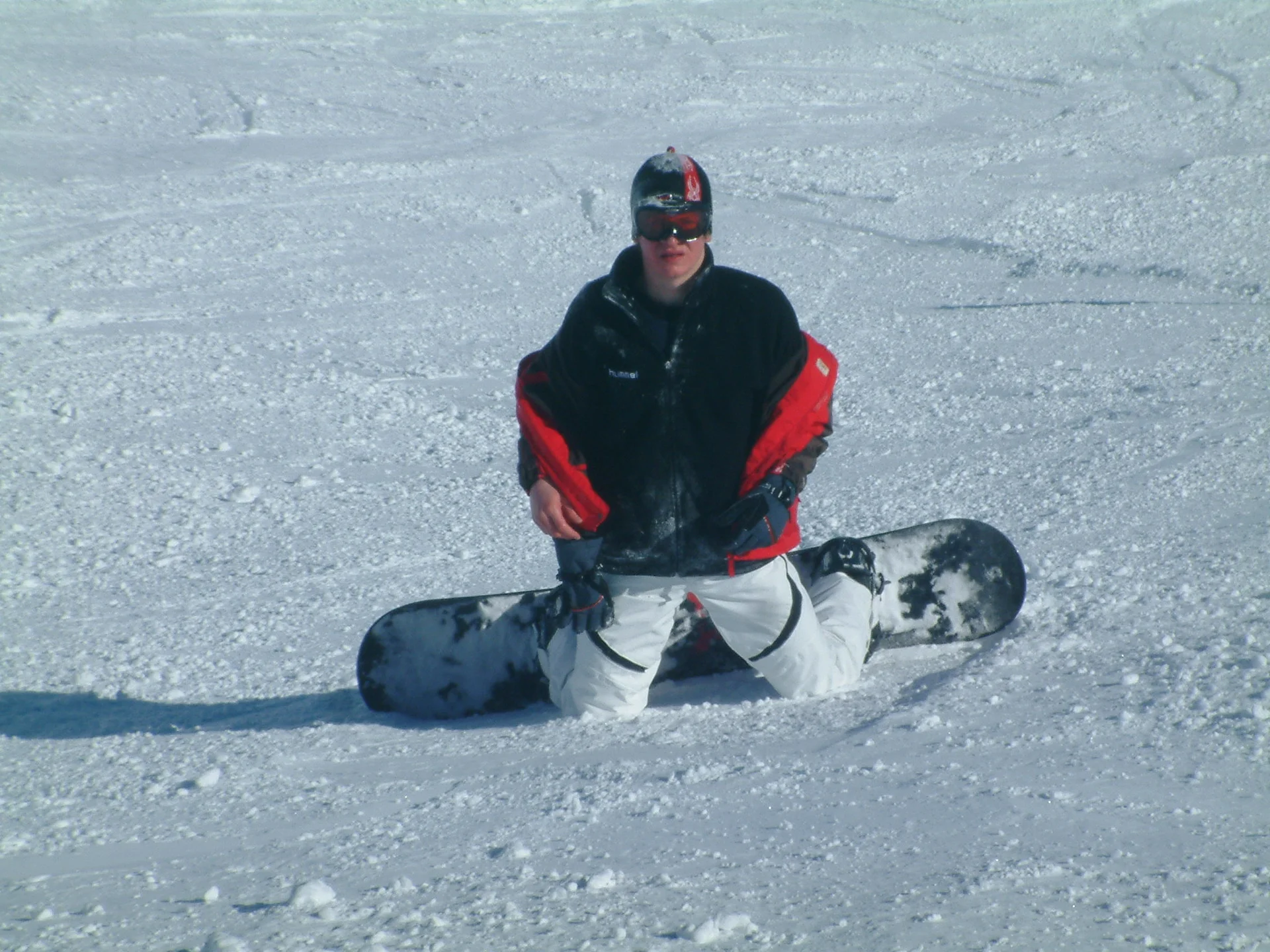 Ein Snowboarder sitzt im Schnee, das Snowboard liegt quer vor ihm, umgeben von einer verschneiten Landschaft. | © DAV Dortmund
