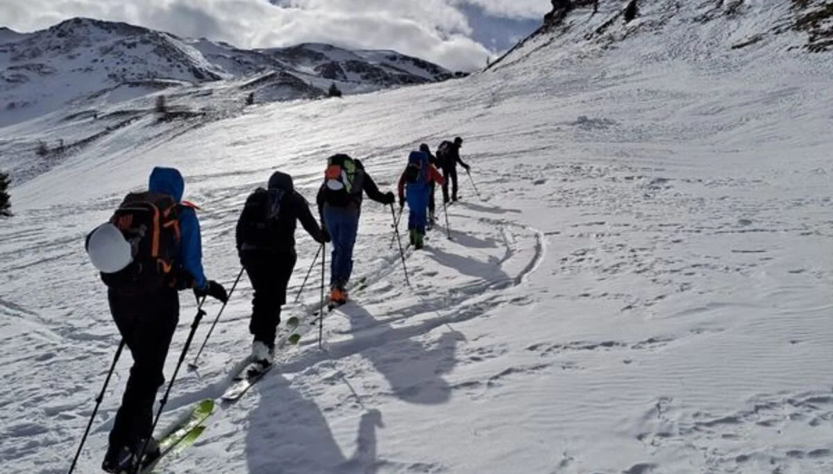 Eine Gruppe Tourengeher*innen steigt mit Ski durch eine verschneite Berglandschaft auf. | © DAV Dortmund