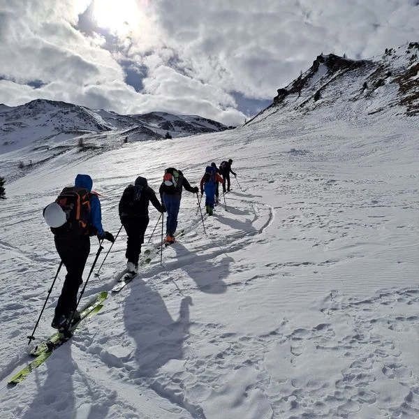 Eine Gruppe Tourengeher*innen steigt mit Ski durch eine verschneite Berglandschaft auf. | © DAV Dortmund