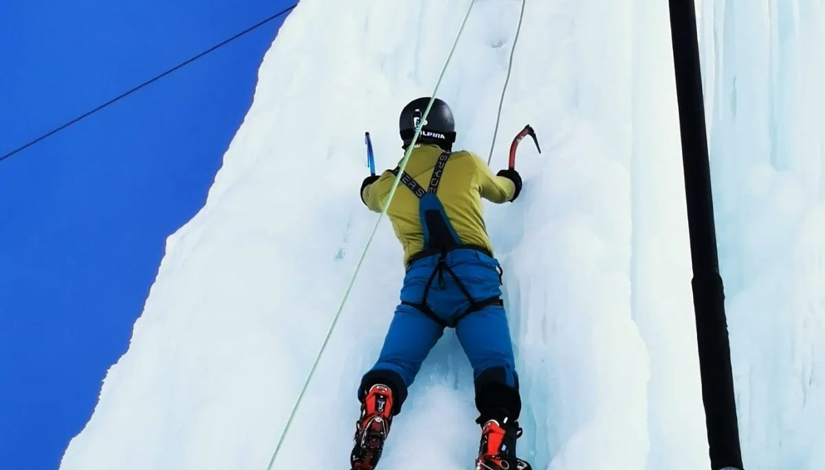 Eine Person klettert mit Steigeisen und Eisgeräten an einer senkrechten Eiswand. | © DAV Dortmund