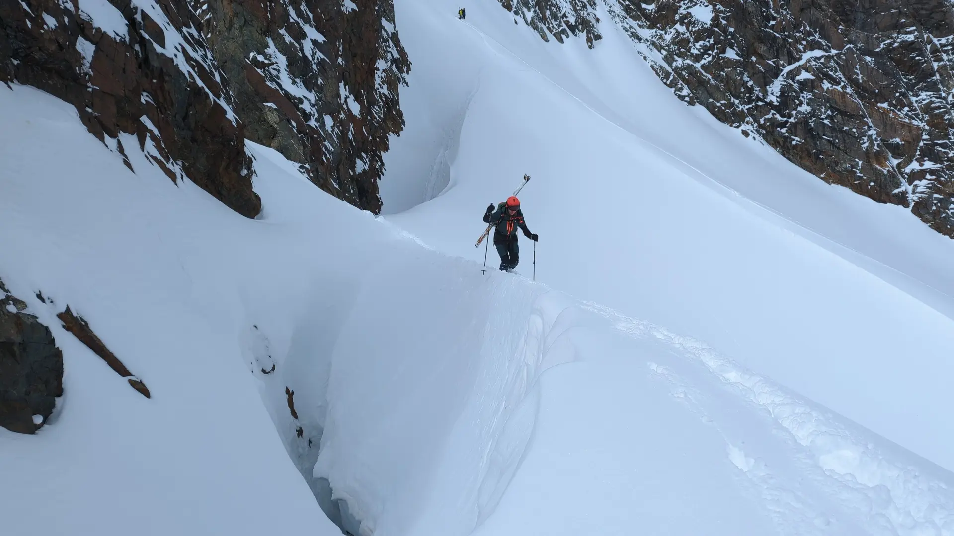 Eine Person geht auf Skitour über einen schmalen Schneekamm mit Spalten im Hochgebirge. | © DAV Dortmund