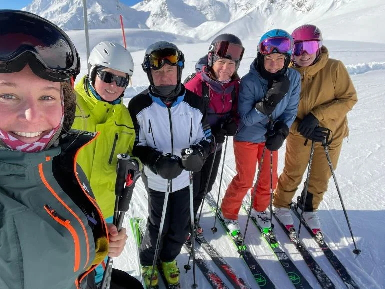 Sechs Skifahrende posieren lachend für ein Gruppenfoto im Schnee. | © DAV Dortmund