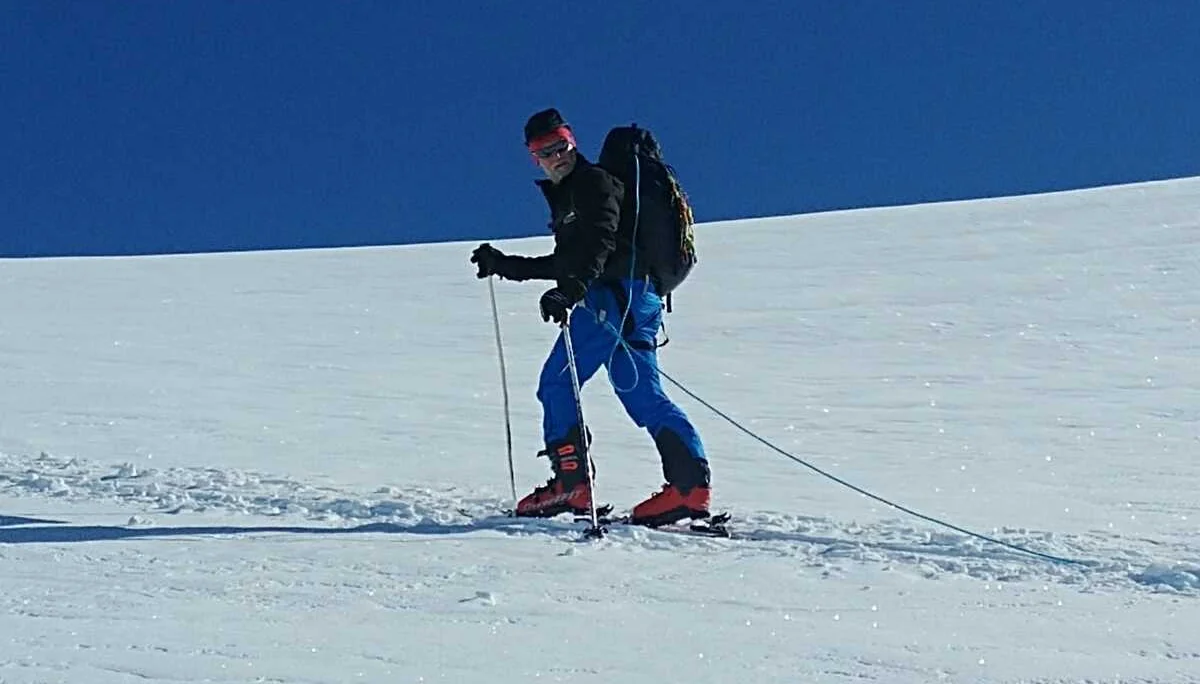 Skitourengeher sichert sich beim Abstieg mit Seil über Schneefeld. | © DAV Dortmund