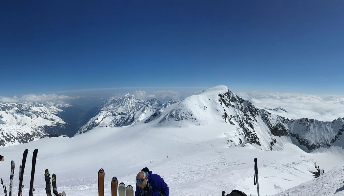 Skigruppe steht am Hang, Skier stecken im Schnee, Panoramablick in die Alpen. | © DAV Dortmund