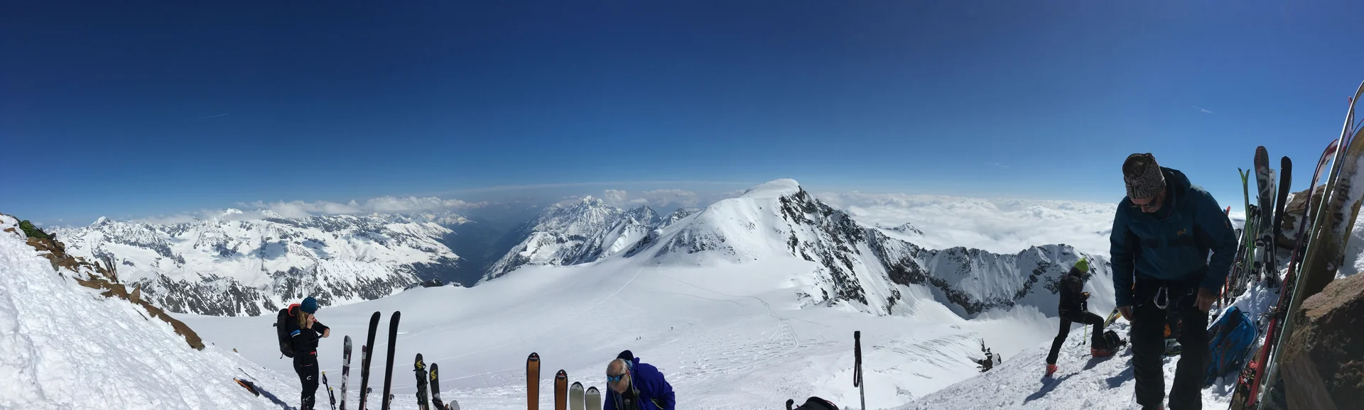 Skigruppe steht am Hang, Skier stecken im Schnee, Panoramablick in die Alpen. | © DAV Dortmund
