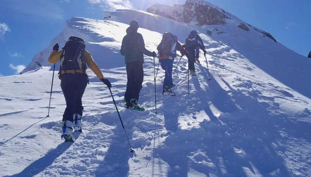 Vier Skitourengeher steigen bei Sonnenschein einen verschneiten Grat hinauf. | © DAV Dortmund