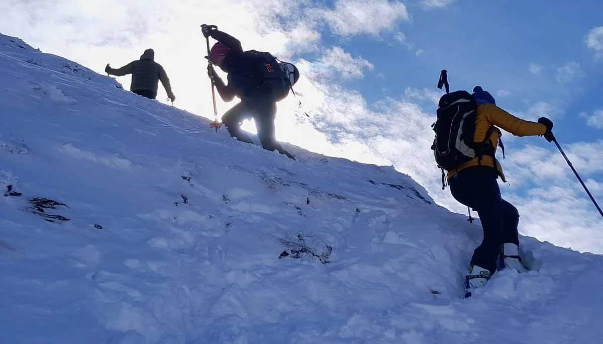Drei Skitourengeher steigen bei tief stehender Sonne einen verschneiten Hang hinauf. | © DAV Dortmund
