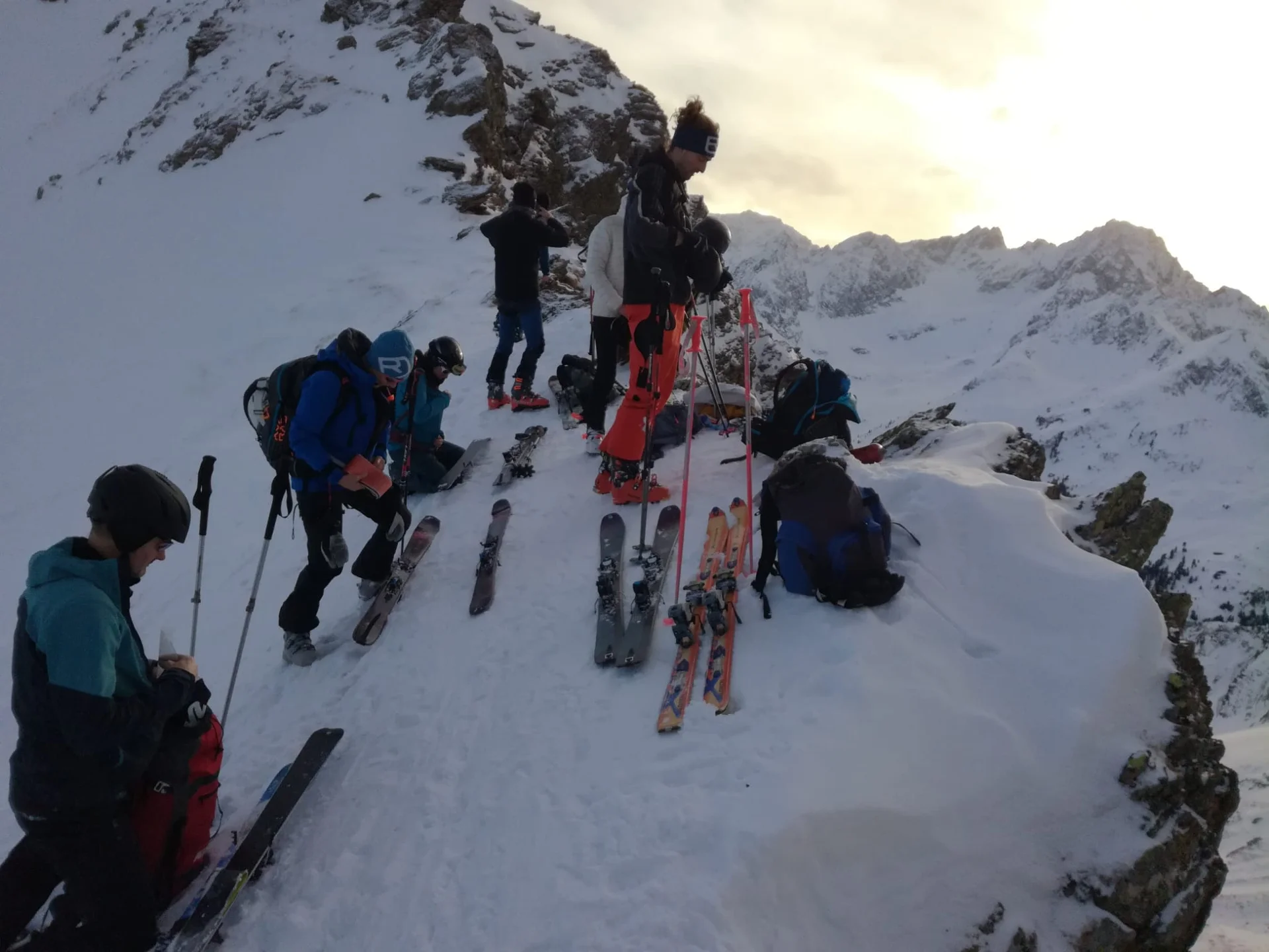 Gruppe bereitet sich auf Skitour vor und befestigt die Ski am Rucksack in alpinem Gelände. | © DAV Dortmund