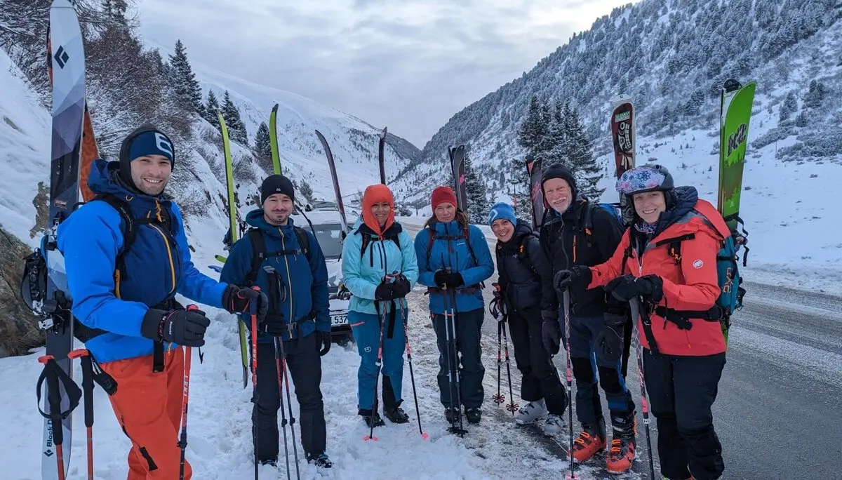 Gruppe von Skitourengeher*innen steht mit Tourenski bereit am Parkplatz im Schnee. | © DAV Dortmund