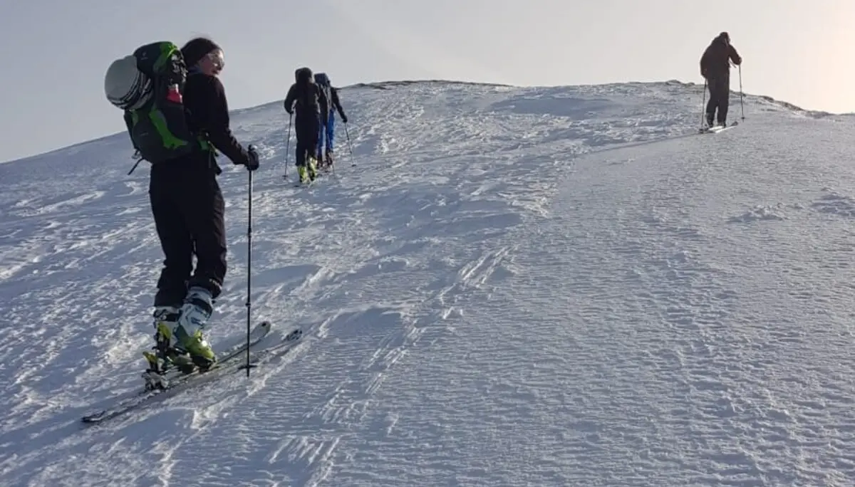 Drei Skitourende gehen in einer Linie den letzten Anstieg über eine glatte Schneekuppe hinauf. | © DAV Dortmund