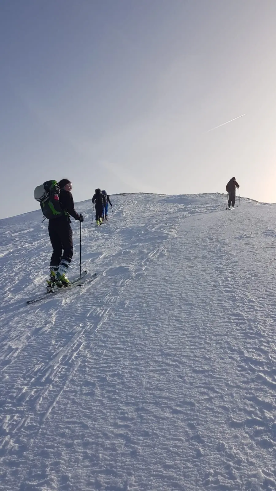 Drei Skitourende gehen in einer Linie den letzten Anstieg über eine glatte Schneekuppe hinauf. | © DAV Dortmund