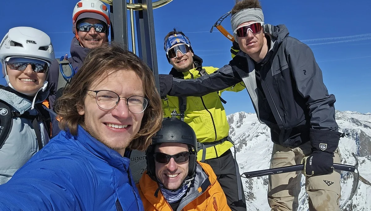 Sechs Bergsteiger*innen mit Helm und Eispickel posieren bei strahlendem Sonnenschein am Gipfel. | © DAV Dortmund