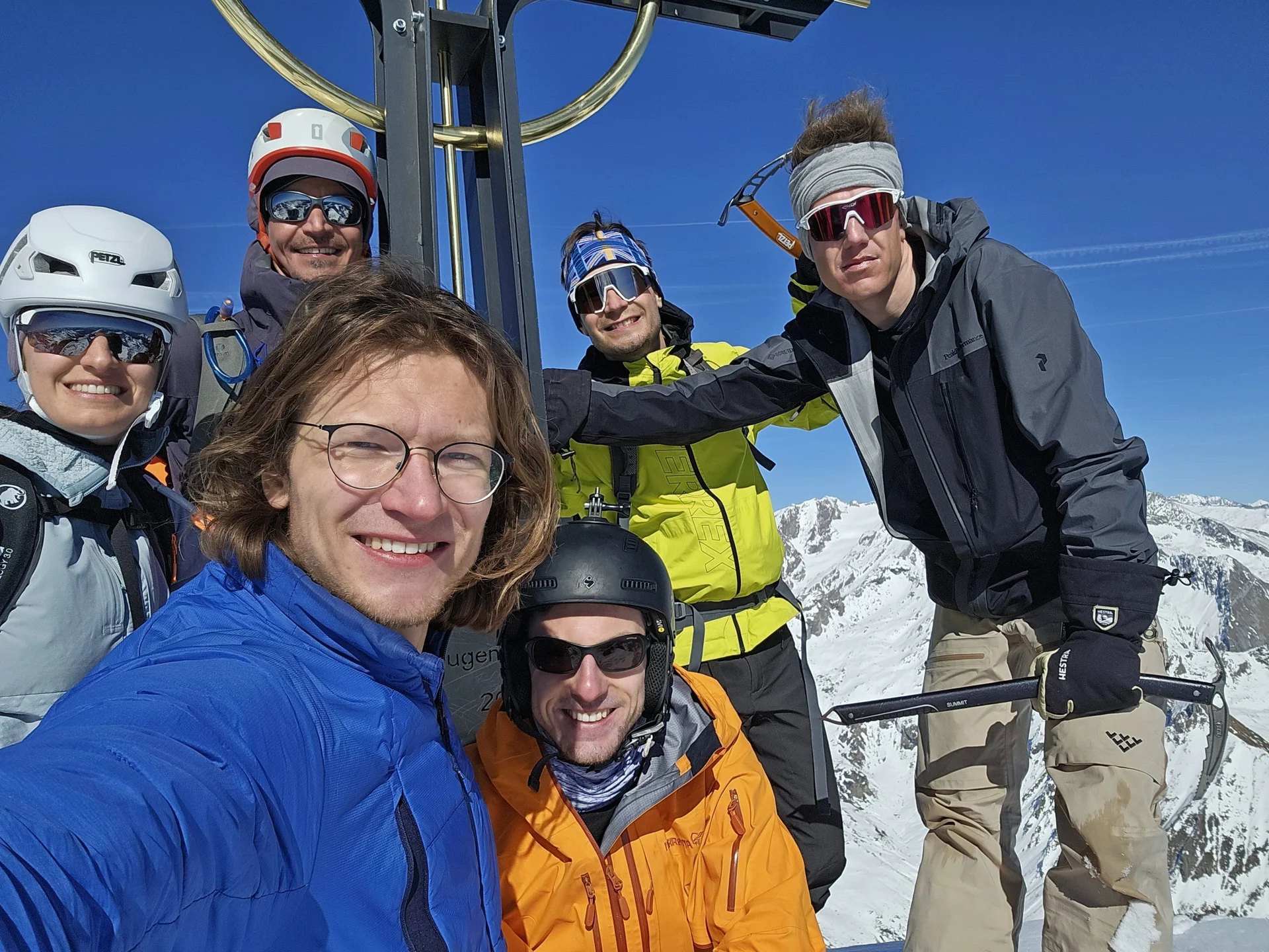 Sechs Bergsteiger*innen mit Helm und Eispickel posieren bei strahlendem Sonnenschein am Gipfel. | © DAV Dortmund