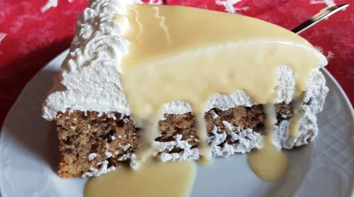 Ein Stück Nusskuchen mit Schlagsahne und Vanillesoße auf einem weißen Teller. | © DAV Dortmund