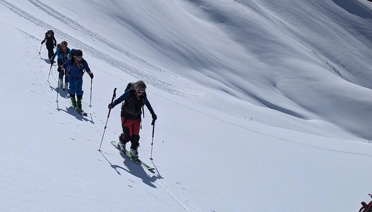 Fünf Personen mit Skiern steigen über einen weiten, verschneiten Hang bergauf. | © DAV Dortmund