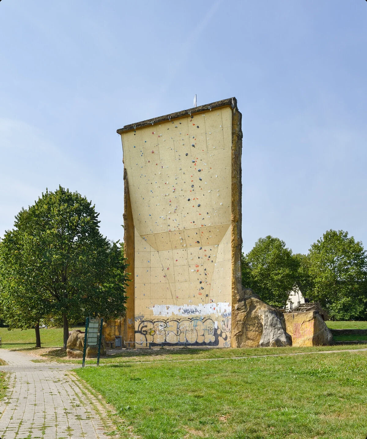 nsicht des Kletterturms mit sichtbarer beschraubter Kletterfläche, Wiese und Bänke. | © DAV Dortmund