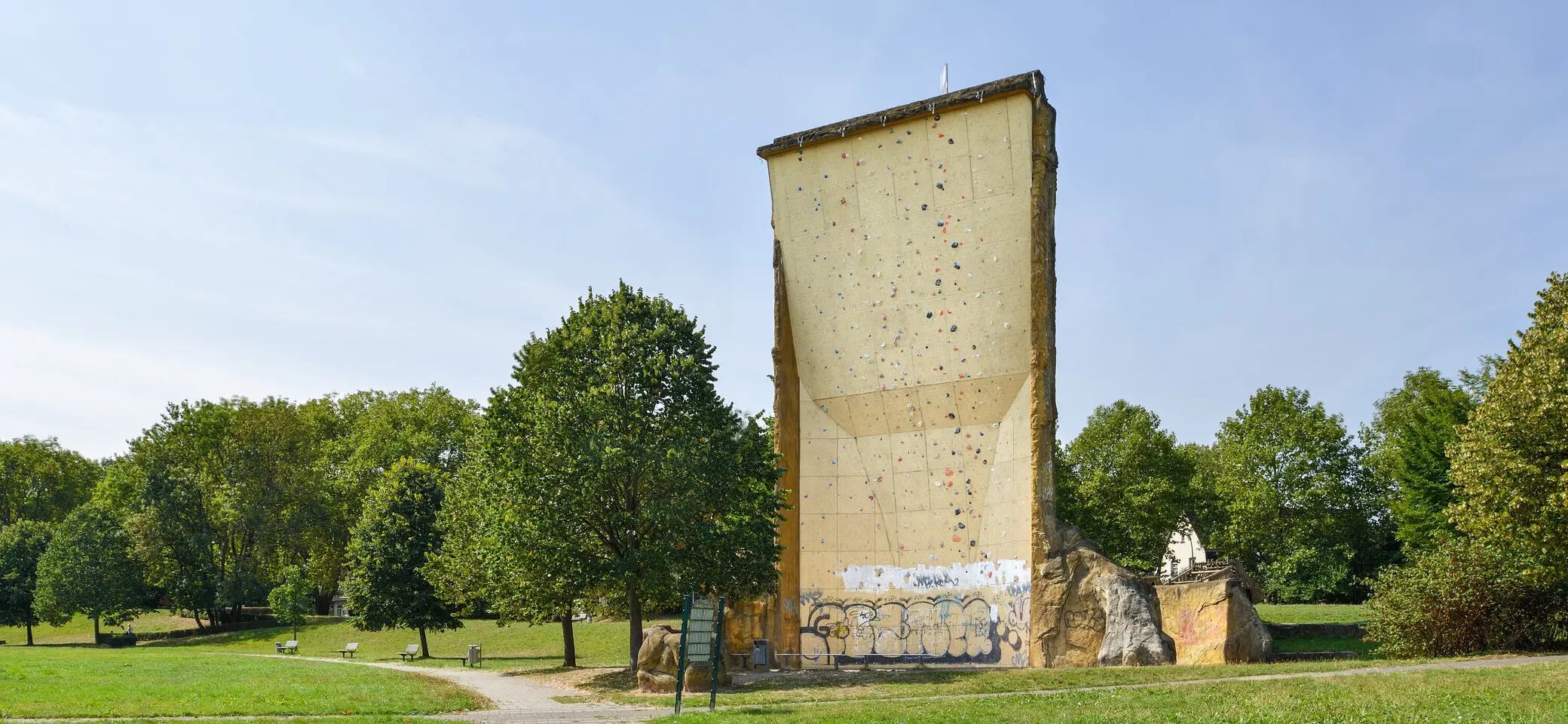 nsicht des Kletterturms mit sichtbarer beschraubter Kletterfläche, Wiese und Bänke. | © DAV Dortmund