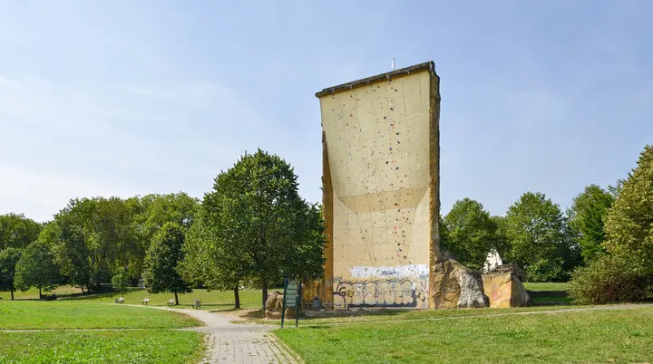 nsicht des Kletterturms mit sichtbarer beschraubter Kletterfläche, Wiese und Bänke. | © DAV Dortmund