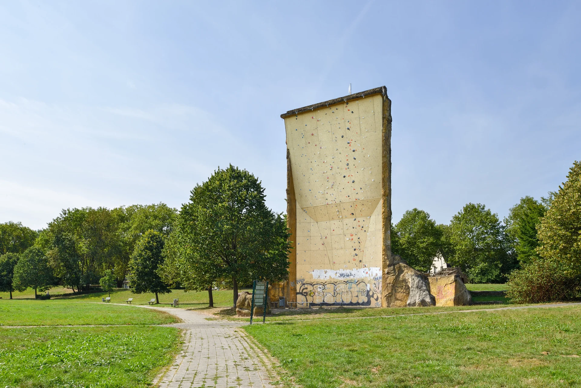 nsicht des Kletterturms mit sichtbarer beschraubter Kletterfläche, Wiese und Bänke. | © DAV Dortmund