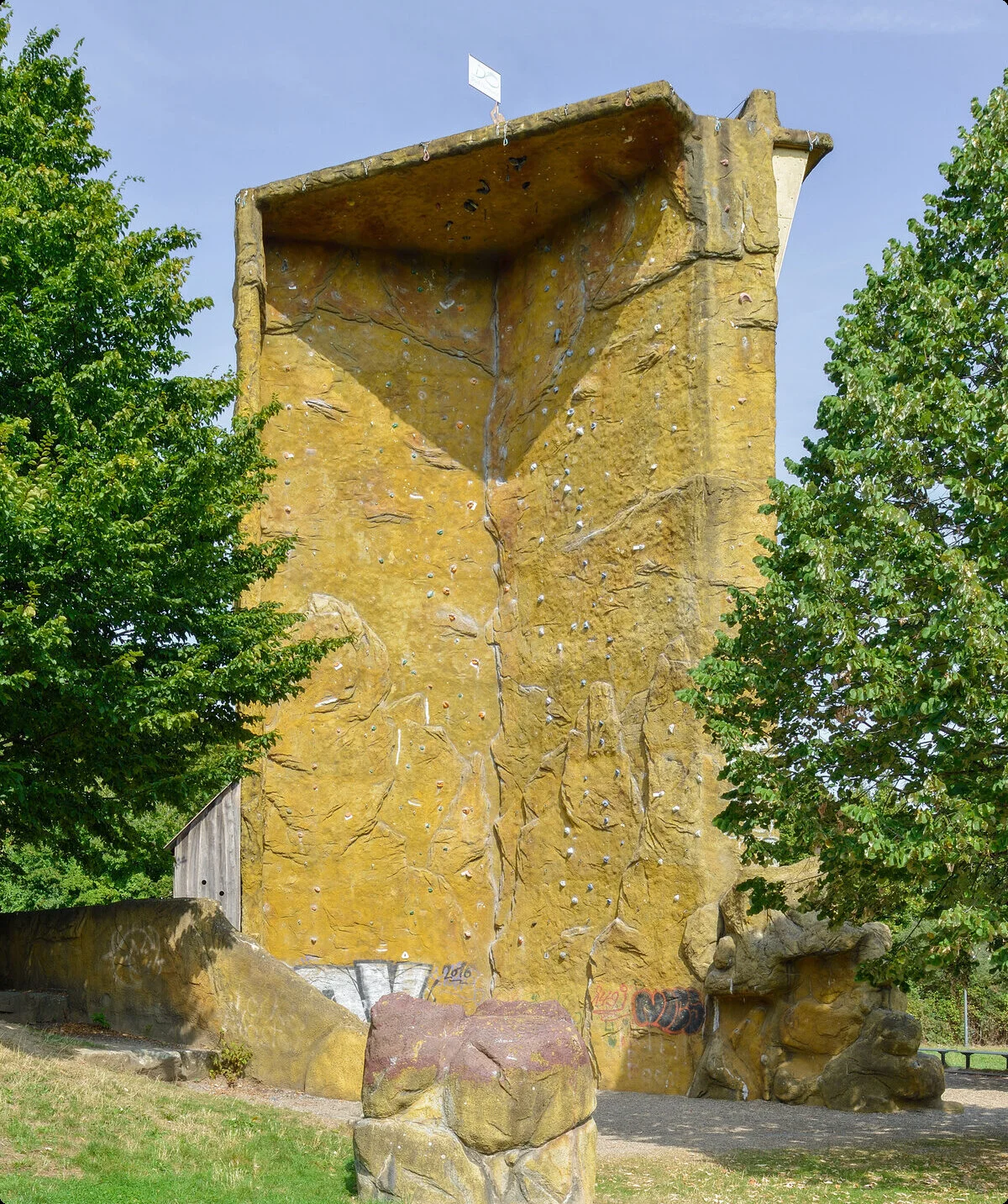 Kletterturm zwischen Bäumen, gelbe Oberfläche, hohe Wandhöhe sichtbar. | © DAV Dortmund