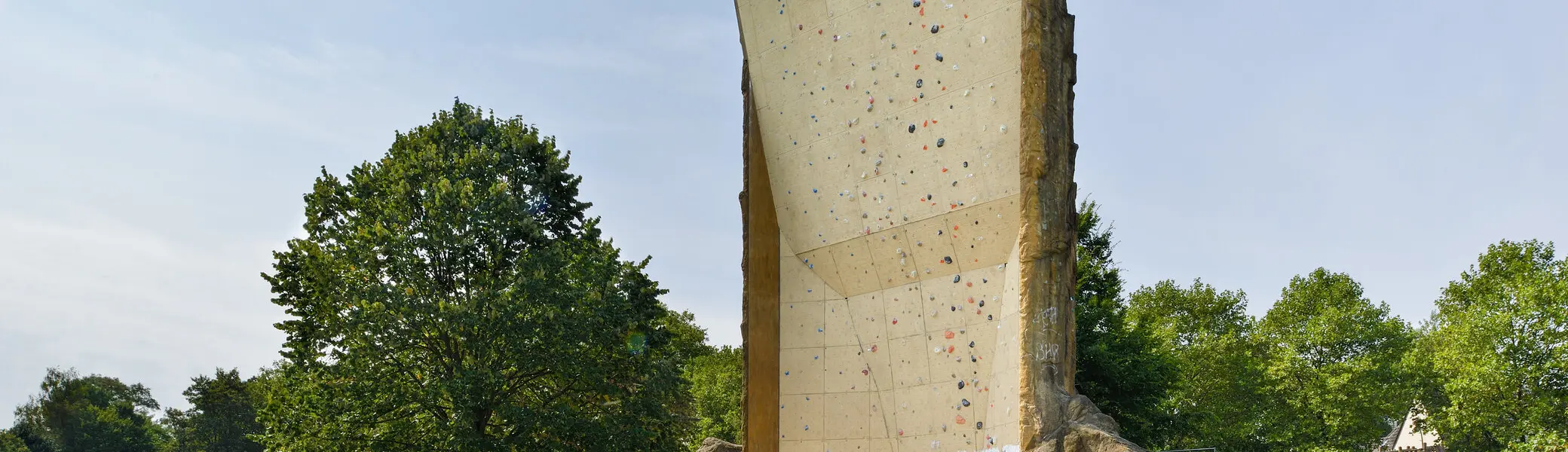 Rückseite des Kletterturms mit markanter Riss- und Strukturfläche, Wiese im Vordergrund. | © DAV Dortmund