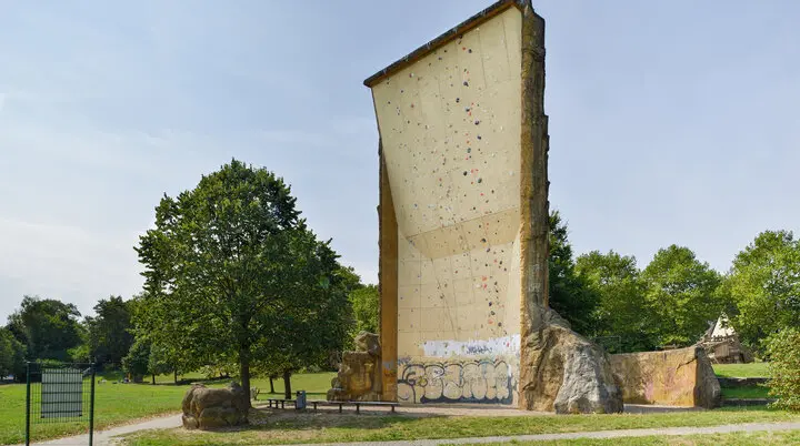 Rückseite des Kletterturms mit markanter Riss- und Strukturfläche, Wiese im Vordergrund. | © DAV Dortmund