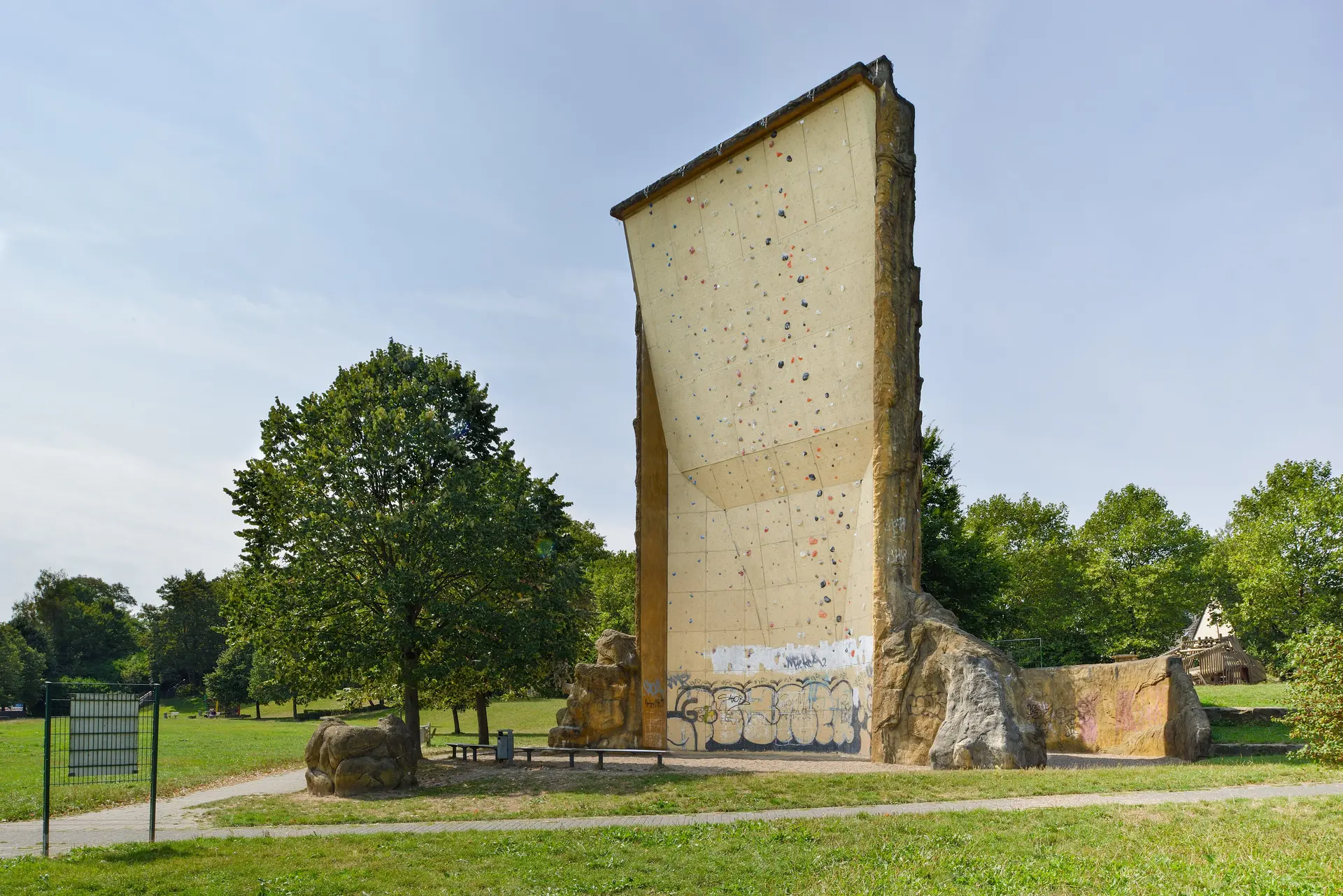 Rückseite des Kletterturms mit markanter Riss- und Strukturfläche, Wiese im Vordergrund. | © DAV Dortmund