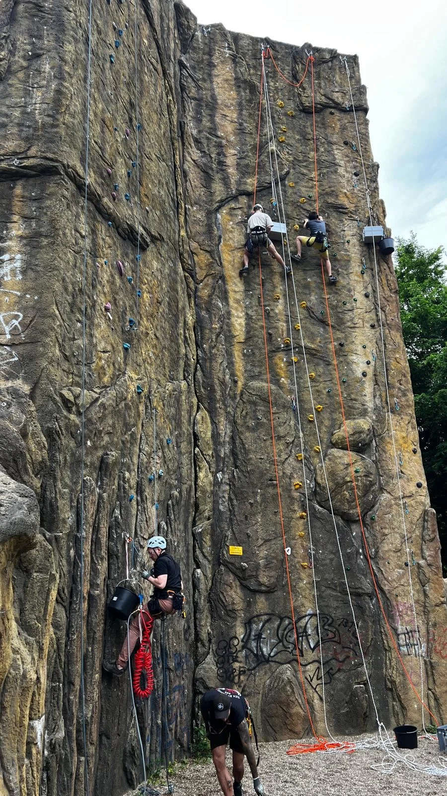 3 Kletterer installieren neue Griffe an der Kletterturm | © DAV Dortmund