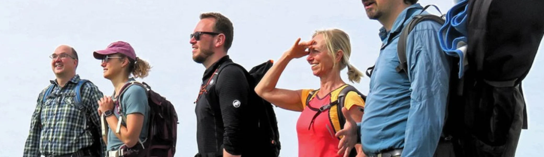 Wandergruppe mit Ausrüstung steht auf einem Hügel mit Blick auf das Ruhrgebiet, WDR-Logo oben. Text: „In die Ruhrgebiets-Alpen mit dem richtigen Wanderrucksack!“ | © WDR // Jens Neuhäuser