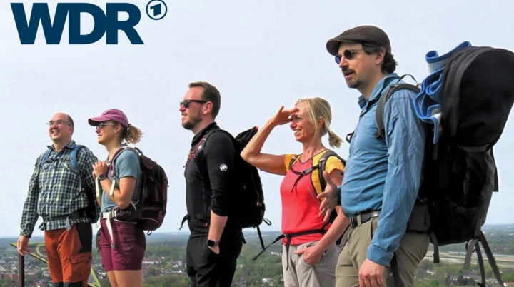 Wandergruppe mit Ausrüstung steht auf einem Hügel mit Blick auf das Ruhrgebiet, WDR-Logo oben. Text: „In die Ruhrgebiets-Alpen mit dem richtigen Wanderrucksack!“ | © WDR // Jens Neuhäuser