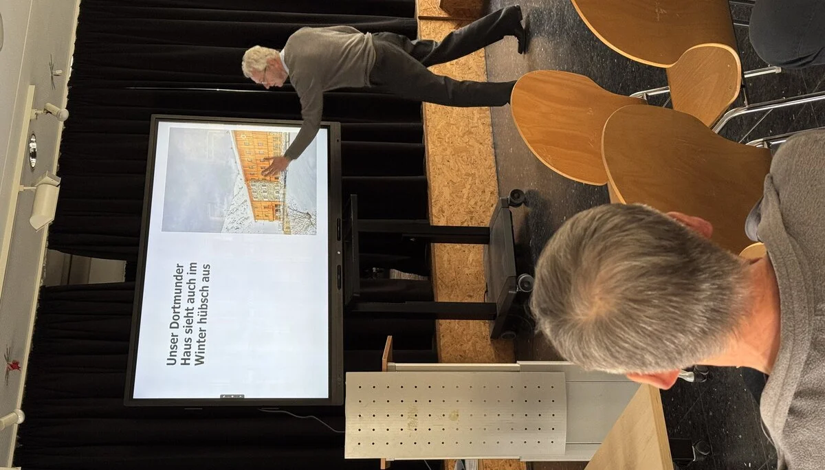 Person zeigt auf eine Folie mit Visualisierung des geplanten DAV-Zentrums, Vortragssituation. | © DAV Dortmund